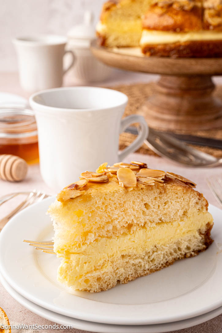Bee Sting Cake features a soft brioche base, honey-almond topping, and creamy vanilla filling — a dreamy German dessert everyone will love! #beestingcake #bienenstich A slice of Bee Sting Cake with honey-almond topping and creamy vanilla filling