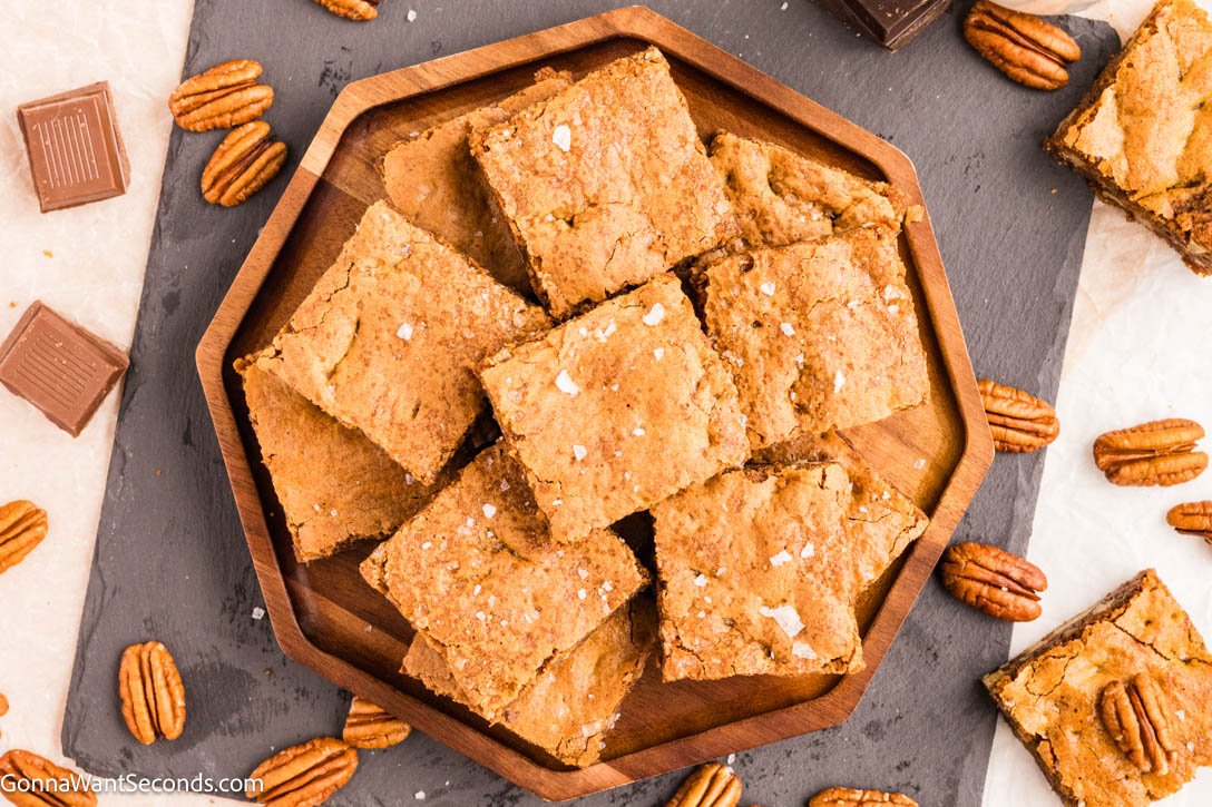 Rich, chewy Brown Butter Blondies with nutty pecans, melty chocolate, and bold butterscotch flavor. Easy, delicious, and perfect for sharing. #brownbutter #blondies slices of brown butter blondies on a serving platter
