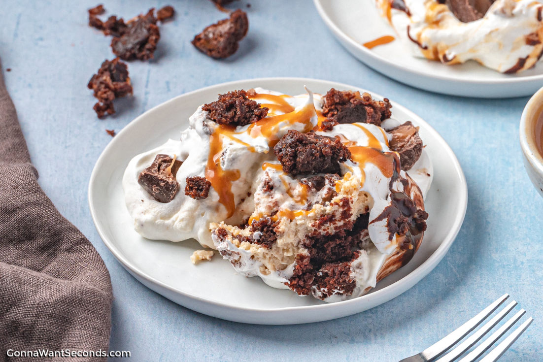 Rich layers of fudgy brownies, caramel mousse, whipped cream, and ganache make this Salted Caramel Brownie Trifle pure dessert bliss. #brownietrifle #trifle Salted Caramel Brownie Trifle on a plate