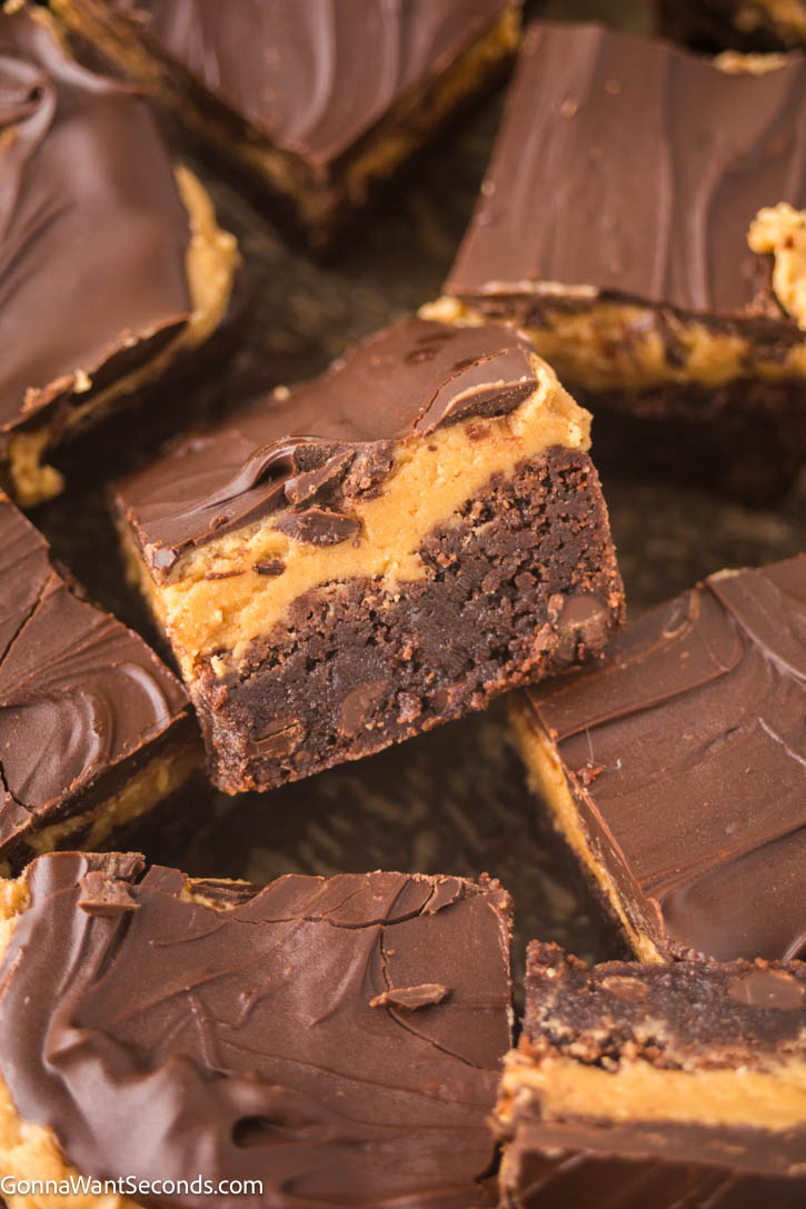 Ultra-fudgy Buckeye Brownies with a creamy peanut butter layer + glossy chocolate topping. A Nostalgic chocolate-PB dessert everyone loves. #buckeyerecipes #brownies Slices of Buckeye Brownies with a creamy peanut butter layer and glossy chocolate topping.