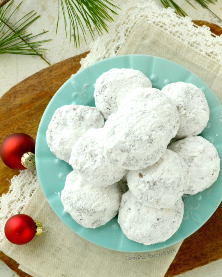 Chocolate Snowball Cookies are rich, double-chocolate holiday cookies rolled in powdered sugar. Tender, fudgy, and so festive for cookie trays! #chocolatecookies #snowballcookies a plate of chocolate snowball cookies
