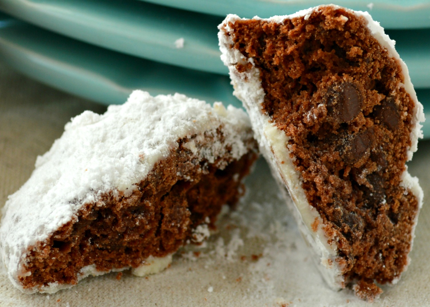 Chocolate Snowball Cookies are rich, double-chocolate holiday cookies rolled in powdered sugar. Tender, fudgy, and so festive for cookie trays! #chocolatecookies #snowballcookies chocolate snowball cookies cut in half