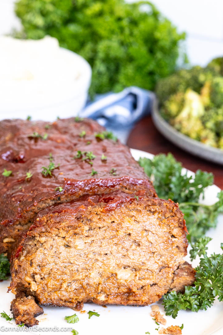 This Lipton Onion Soup Meatloaf is juicy, flavorful, and topped with a tangy glaze—classic comfort food made easy and always perfectly tender. #meatloaf #liptononionsoup whole Lipton Onion Soup Meatloaf with a slice taken out, showing the juiciness inside