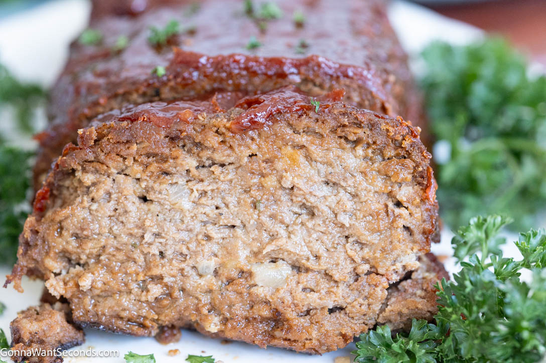 This Lipton Onion Soup Meatloaf is juicy, flavorful, and topped with a tangy glaze—classic comfort food made easy and always perfectly tender. #meatloaf #liptononionsoup whole Lipton Onion Soup Meatloaf with a slice taken out, showing the juiciness inside