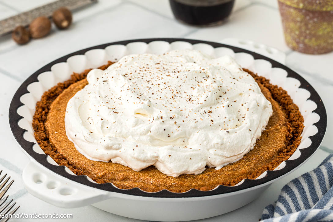 Light, airy pumpkin chiffon pie with warm spices and a buttery Biscoff crust. A dreamy make-ahead holiday dessert your family will love. #pumpkinpie #chiffonpie whole pumpkin chiffon pie with Biscoff crust and whipped topping