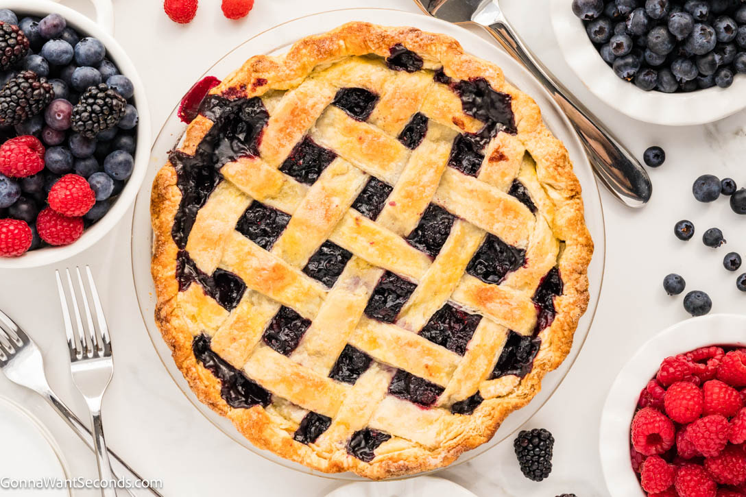 This Razzleberry Pie is made with frozen raspberries, blackberries, and blueberries, nestled inside a golden, buttery crust with a sparkling lattice top. #berrypie #razzleberrypie a whole razzleberry pie with lattice top