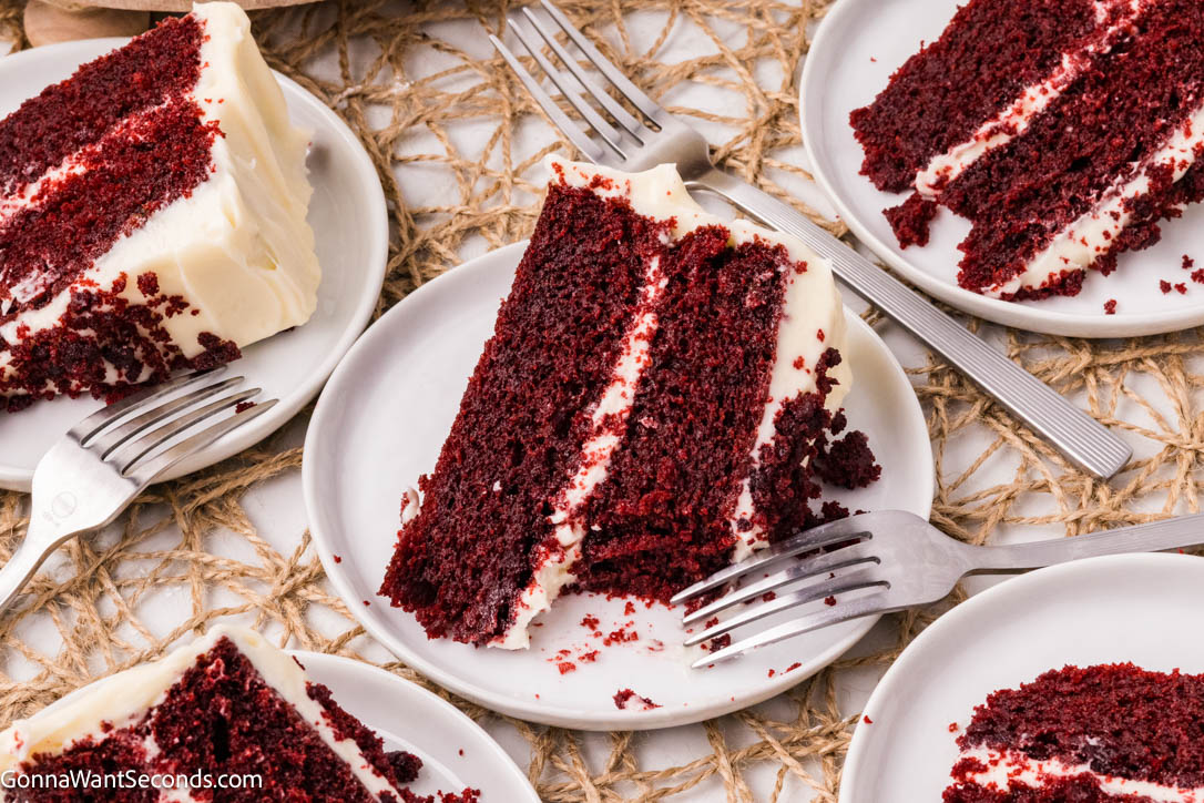 Red velvet cake is ultra moist, cocoa-kissed, and topped with tangy cream cheese frosting—an easy, bakery-style classic your family will crave. #redvelvetcake #redvelvet a slice of Red velvet cake topped with cream cheese frosting