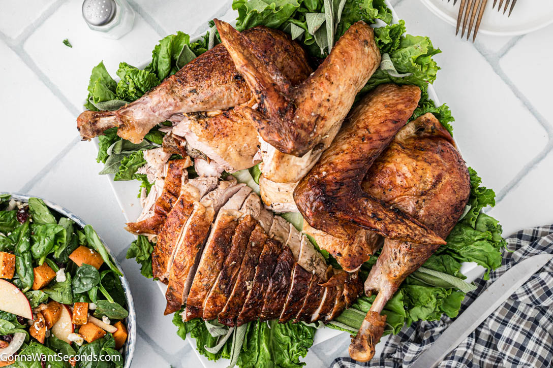 Golden, juicy roasted turkey + silky homemade gravy—step-by-step tips, foolproof flavor, and everything you need for a perfect holiday bird. #roastedturkey #turkeyrecipes sliced roasted turkey on a serving platter