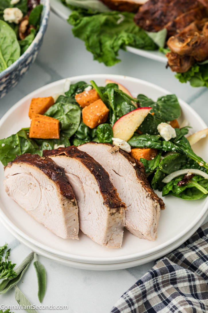 Golden, juicy roasted turkey + silky homemade gravy—step-by-step tips, foolproof flavor, and everything you need for a perfect holiday bird. #roastedturkey #turkeyrecipes slices of roasted turkey with salad on the side on a plate