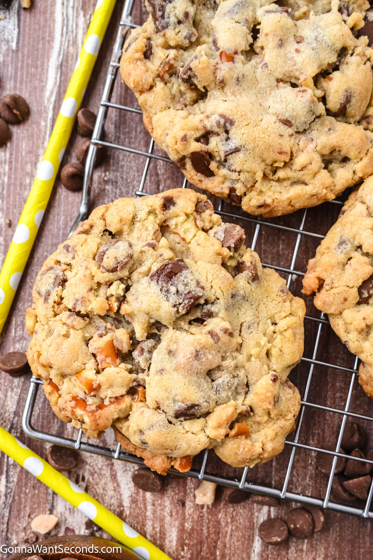 This sweet and salty Rockstar Cookie is loaded with milk chocolate chips, semi-sweet chunks, crunchy pretzels, buttery toffee bits, with sea salt on top. #rockstarcookies Rockstar Cookie on a cooling rack