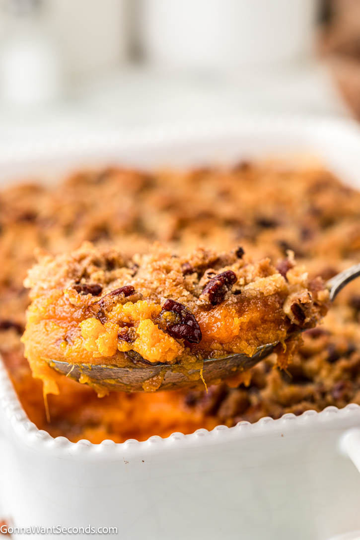This Ruth’s Chris Sweet Potato Casserole has silky smooth sweet potatoes, with golden and crisp brown sugar–pecan topping. It's the best holiday side dish! #sweetpotatoes #sweetpotatocasserole Serving spoon scooping Ruth’s Chris Sweet Potato Casserole