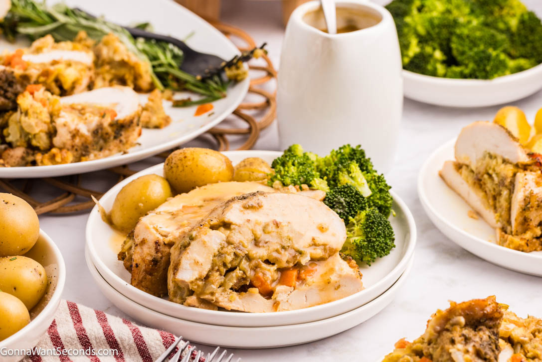 This Stuffed Turkey Breast is tender, juicy, and filled with a cozy apple-herb stuffing that tastes like the very best parts of Thanksgiving. #stuffedturkeybreast #turkeybreast Stuffed Turkey Breast with apple-herb stuffing on a plate