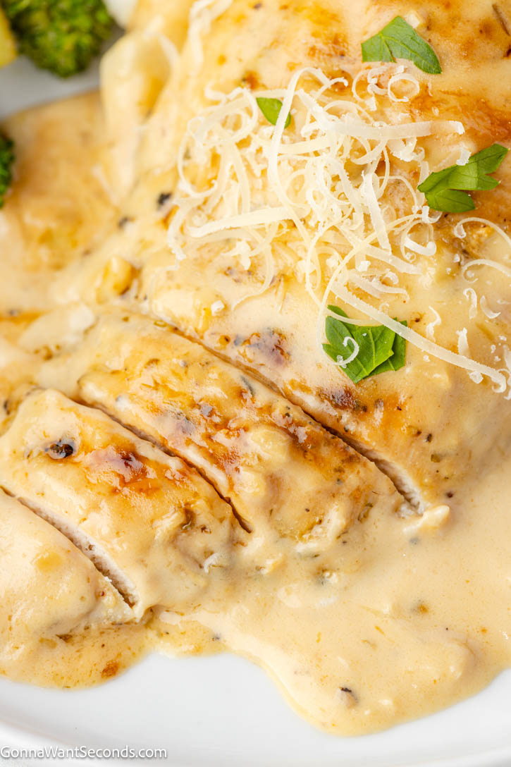 Creamy garlic chicken with tender seared chicken in a rich Parmesan cream sauce. Balanced, silky, and perfect over pasta or mashed potatoes. #creamygarlicchicken #garlicchicken Creamy garlic chicken smothered in Parmesan cream sauce on a plate