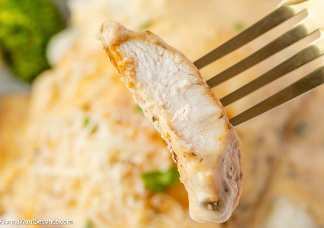 Creamy garlic chicken with tender seared chicken in a rich Parmesan cream sauce. Balanced, silky, and perfect over pasta or mashed potatoes. #creamygarlicchicken #garlicchicken fork piercing a piece of Creamy garlic chicken