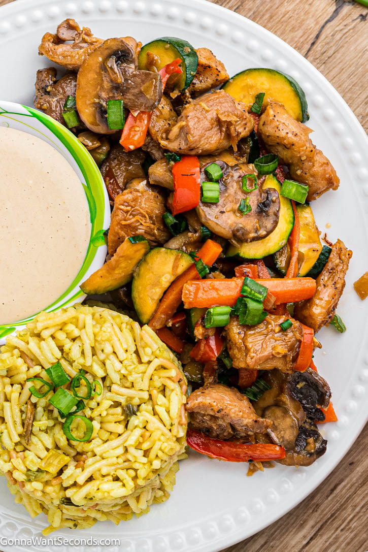 This Benihana-style hibachi chicken is juicy, buttery, and full of flavor—an easy one-skillet dinner the whole family devours. #hibachichicken #oneskilletdinner Hibachi-Style Chicken with rice and sauce on a plate