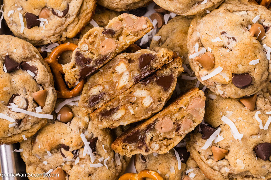 These brown butter kitchen sink cookies are thick and chewy, packed with chocolate, salted caramel, coconut, and crunchy pretzels—bakery-style too. #kitchensinkcookies #cookies Kitchen sink cookies broken in half