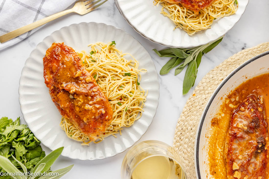 Chicken Saltimbocca is a fancy but easy, 30-minute pan-seared chicken cutlet, elegantly topped with sage and prosciutto, with white wine butter sauce. #chickensaltimbocca #30minutemeals a piece of Chicken Saltimbocca coated with sauce on top of pasta on a plate