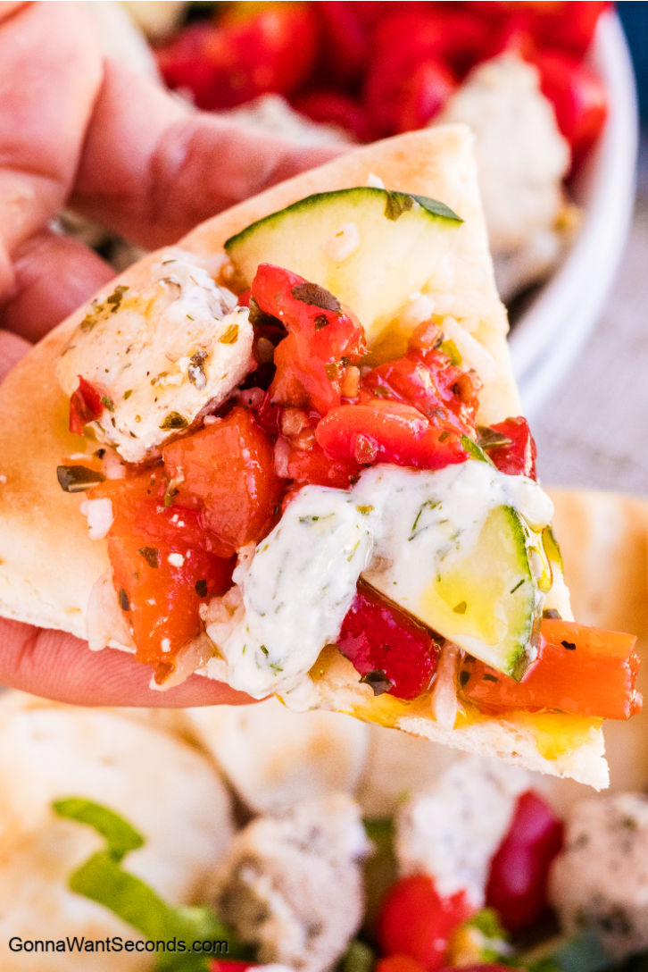 Greek Chicken Bowls are made with yogurt-marinated chicken, roasted red peppers, feta, olives, crisp veggies, and vinaigrette. It's fresh, flexible, and easy! #greekchicken #greekchickenbowls Greek Chicken Bowls scooped by pita bread