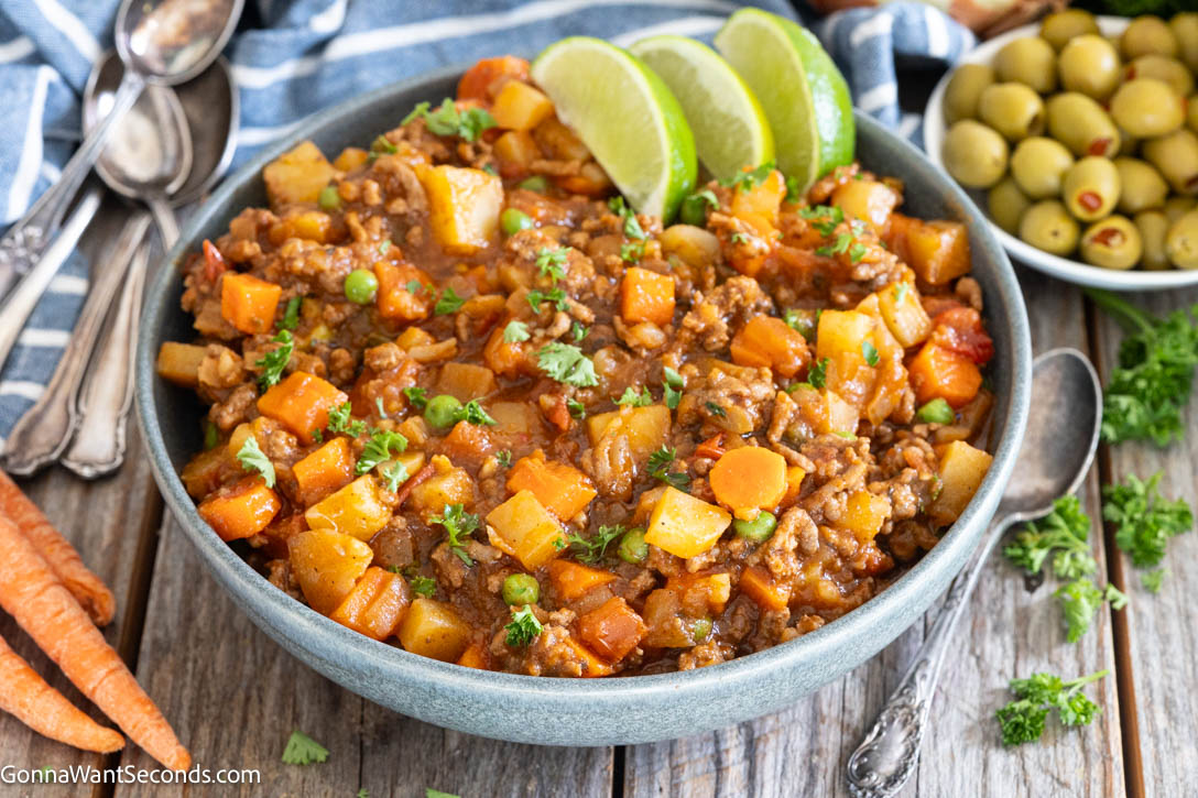 Mexican Picadillo is a cozy, hearty skillet meal with ground beef, potatoes, carrots, and tomatoes. It's simple, affordable, and perfect for busy family dinners. #mexicanfood #picadillo Mexican style picadillo in a bowl garnished with sliced lime