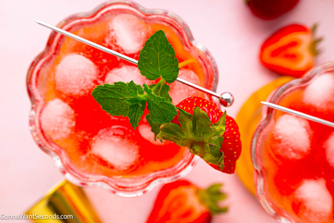 A bubbly, elegant strawberry mocktail perfect for brunches and warm evenings. Fresh strawberries, floral rosé flavor, and herbs shine in this alcohol-free sip. #strawberrymocktails #mocktails Strawberry mocktail garnished with mint leaces in a coupe glass