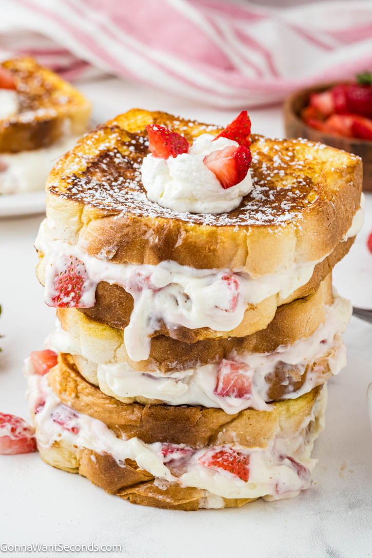Strawberry Stuffed French Toast feels indulgent yet easy, with brioche filled with cream cheese and fresh strawberries, dipped in cinnamon-vanilla custard. #frenchtoast #strawberrystuffedfrenchtoast Strawberry Stuffed French Toast stack on top of each other