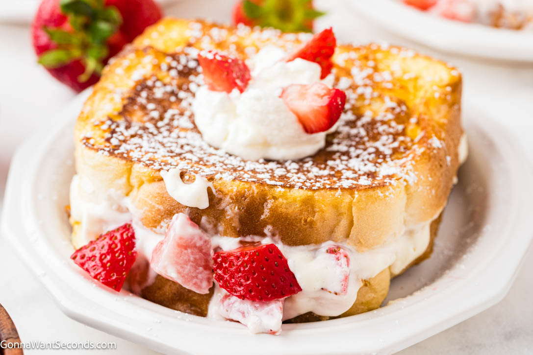 Strawberry Stuffed French Toast feels indulgent yet easy, with brioche filled with cream cheese and fresh strawberries, dipped in cinnamon-vanilla custard. #frenchtoast #strawberrystuffedfrenchtoast Strawberry Stuffed French Toast on a plate