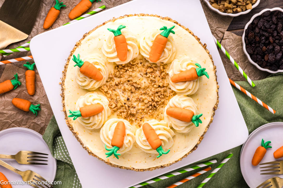 Ultra moist carrot cake with cream cheese frosting and a rich buttermilk glaze. Soft, bakery-style texture and perfectly spiced flavor. #carrotcake #creamcheesefrosting top shot of whole carrot cake with cream cheese frosting decorated with little fondant carrots