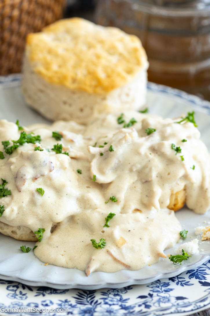 Creamed Chicken Over Biscuits is the ultimate comfort food. Enjoy tender chicken in savory gravy over warm biscuits with this easy, flavor-packed cozy recipe. #creamedchicken #chickenandbiscuits Creamed Chicken Over Biscuits on a plate with a biscuit on the side