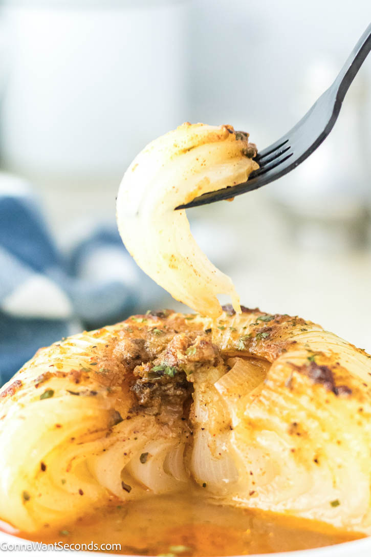 This viral onion boil recipe transforms onions into buttery, melt-in-your-mouth perfection. Easy, bold, and unbelievably good! #onionboil #sidedishes fork piercing a piece of onion boil