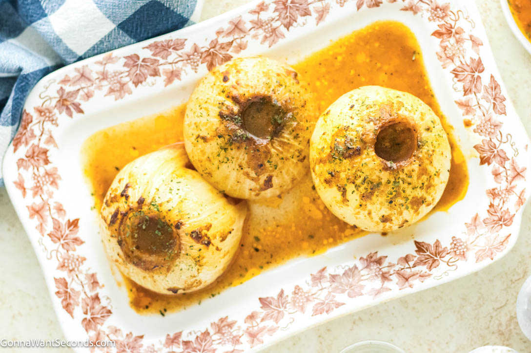 This viral onion boil recipe transforms onions into buttery, melt-in-your-mouth perfection. Easy, bold, and unbelievably good! #onionboil #sidedishes onion boil on a serving platter with cajun sauce