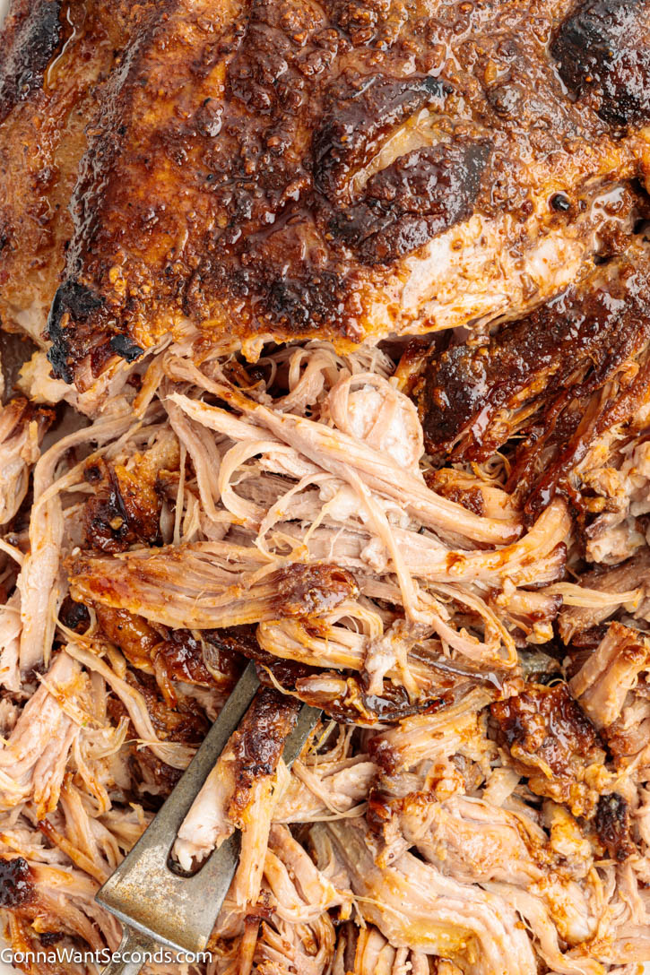 Learn how to cook pork butt in the oven until juicy, tender, and fall-apart perfect. This easy, no-fail method delivers incredible flavor. #ovenroastedpork #roastedpork oven roasted pork butt with half shredded on a serving platter