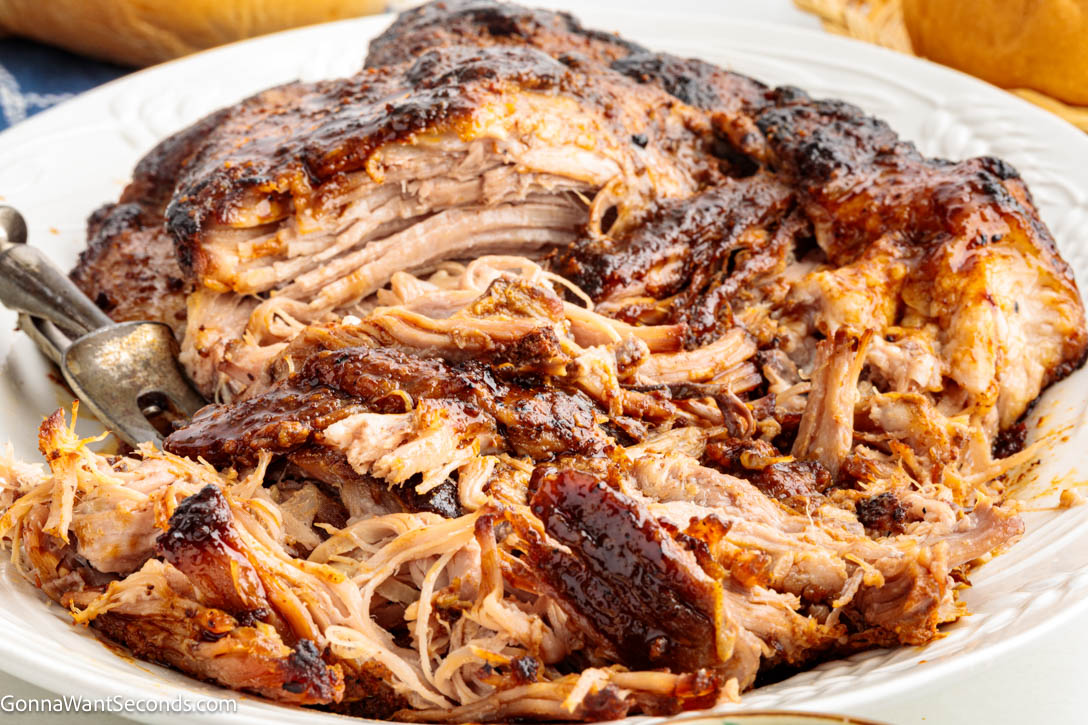 Learn how to cook pork butt in the oven until juicy, tender, and fall-apart perfect. This easy, no-fail method delivers incredible flavor. #ovenroastedpork #roastedpork shredded oven roasted pork butt on a serving platter