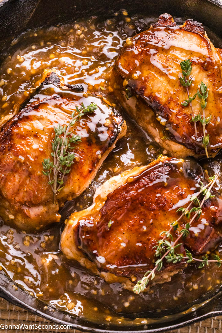 Golden, deeply seared on the outside and unbelievably juicy on the inside, these brown sugar pork chops are everything you want in a comfort dinner. #porkchops #brownsugarporkchops Brown Sugar Pork Chops with sauce in a cast iron skillet