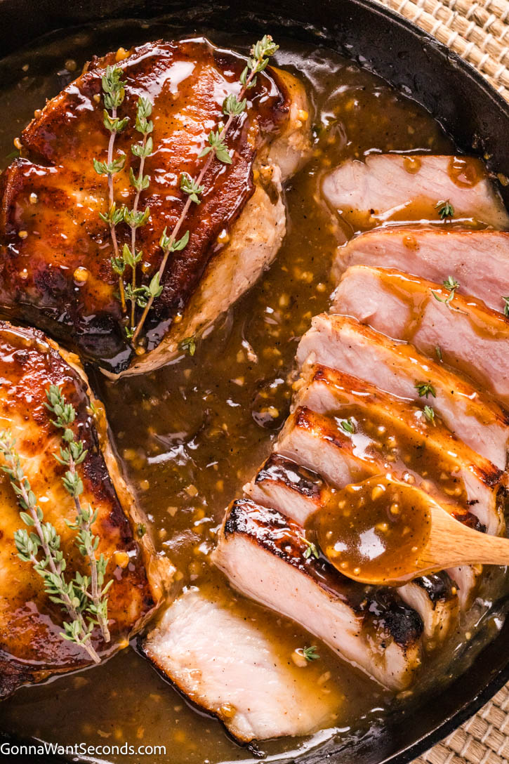 Golden, deeply seared on the outside and unbelievably juicy on the inside, these brown sugar pork chops are everything you want in a comfort dinner. #porkchops #brownsugarporkchops Brown Sugar Pork Chops with sauce in a cast iron skillet
