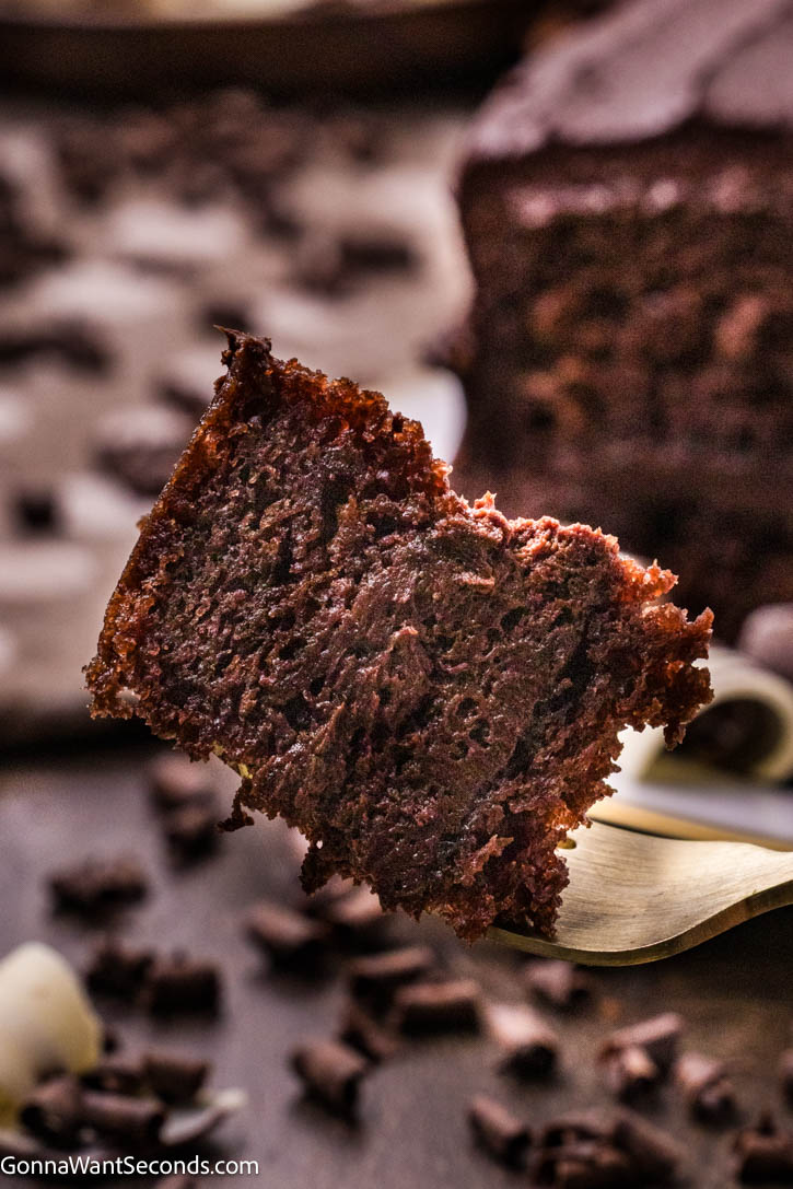 This Best Chocolate Cake is ultra moist, deeply chocolatey, and layered with silky fudge frosting. A rich homemade layer cake everyone will remember. #chocolatecake #bestchocolatecake a piece of best chocolate cake on a fork, close up