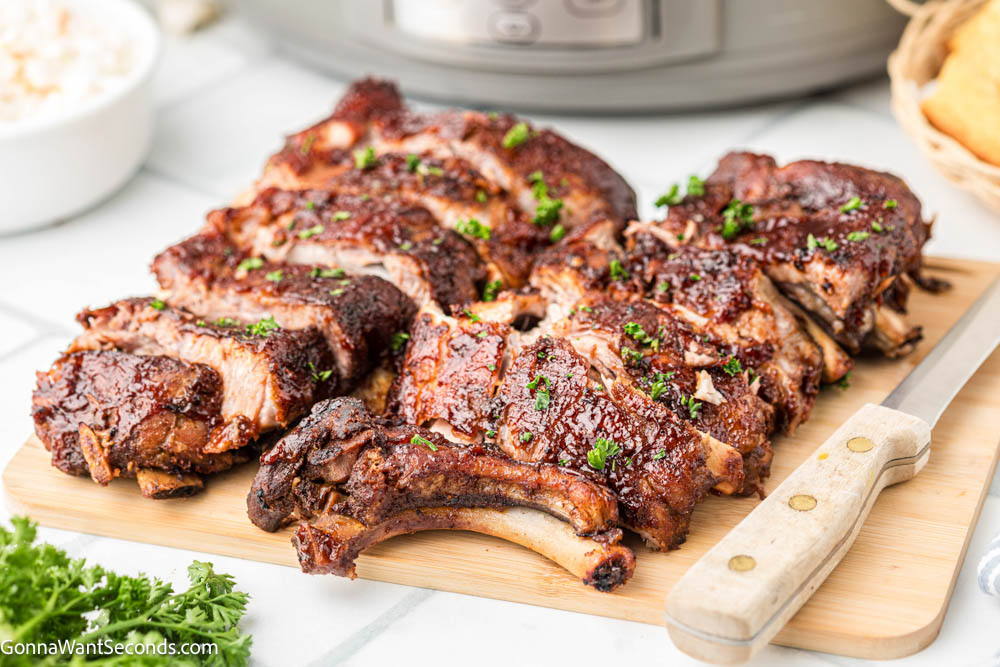 sliced crockpot ribs on a wooden board