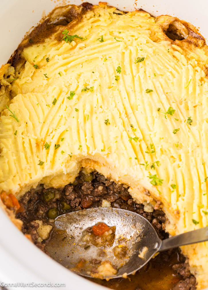 This Crockpot Shepherd's Pie has all the classic flavors: savory beef, rich gravy, tender vegetables, and creamy mashed potatoes, without the fuss of baking. #shepherdspie #crockpotrecipes scooped a portion of Crockpot Shepherd's Pie