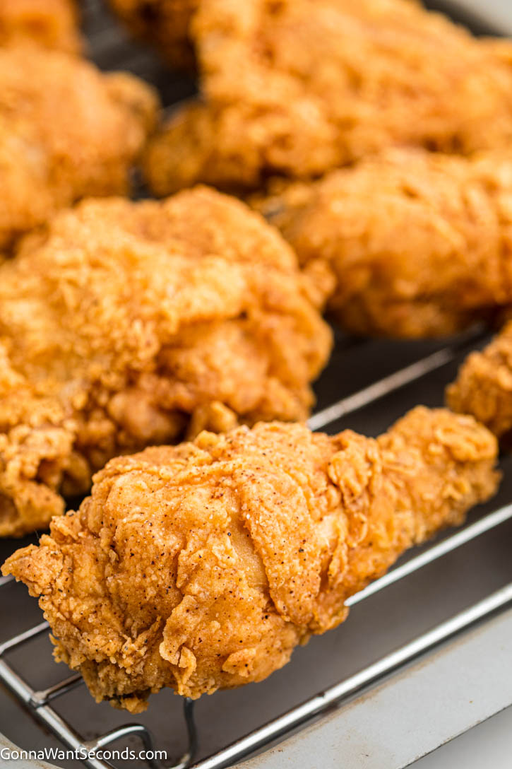 Make the best Fried Chicken Recipe with a crispy, golden crust and juicy, tender chicken. This easy buttermilk fried chicken is perfect every time! #friedchicken #buttermilkfriedchicken Fried Chicken Recipe on a cooling rack