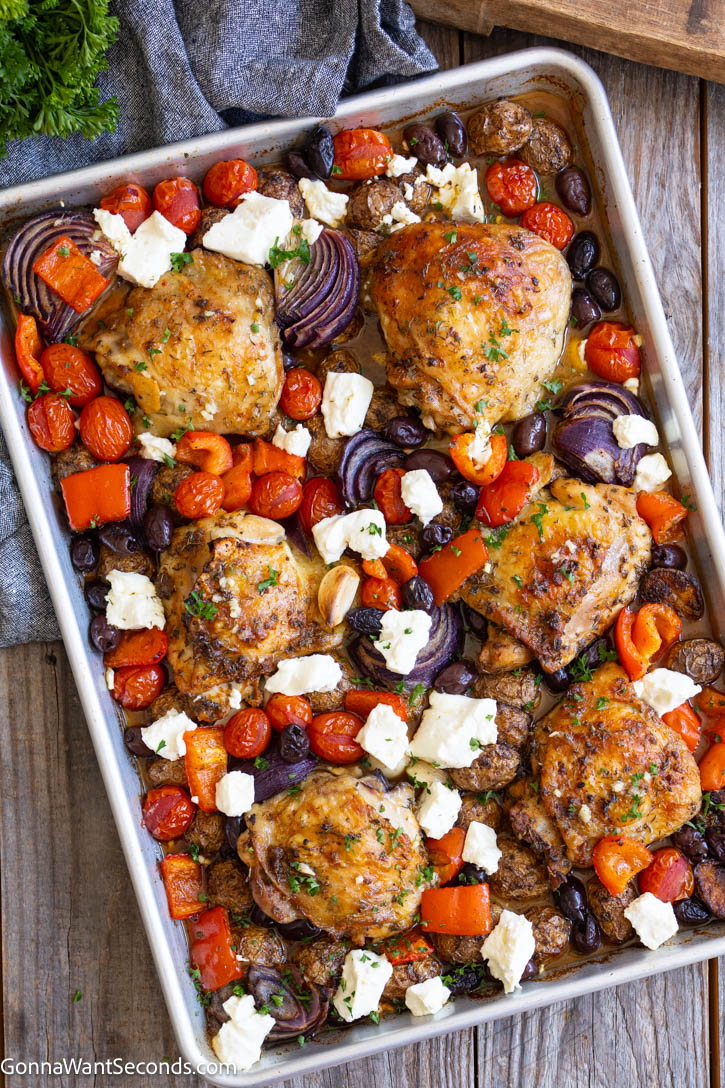 Greek sheet pan chicken with juicy thighs, tender potatoes, colorful vegetables, feta, and a bright lemon-herb sauce. An easy one-pan dinner. #greekchicken #sheetpanchicken Greek sheet pan chicken with juicy thighs, tender potatoes, colorful vegetables, feta on a sheet pan