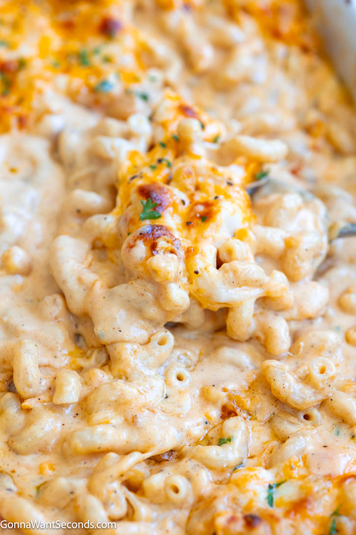 Tini’s Mac and Cheese is ultra creamy, cheesy, and packed with flavor. This viral mac and cheese recipe bakes up rich with the perfect cheese pull. #tinismacandcheese #macncheese Scooping Tini’s Mac and Cheese in the casserole