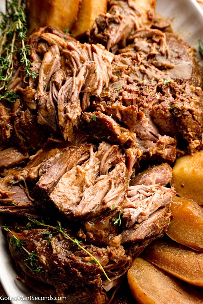 Apple cider braised pork shoulder cooks low and slow until fall-apart tender, with sweet-tart apples, red onions, and a savory cider-Dijon sauce. #braisedporkshoulder #appleciderbraisedpork fall-apart tender Apple cider braised pork shoulder close up