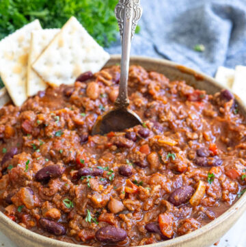 A bowl of crockpot chili topped with crackers